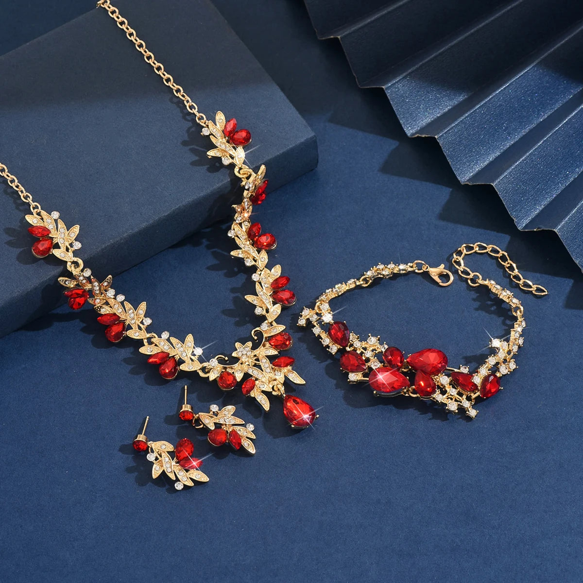 A set of fashionable and exquisite alloy diamond-encrusted, red crystal pendant necklace, earrings and bracelet, ladies' jewelry